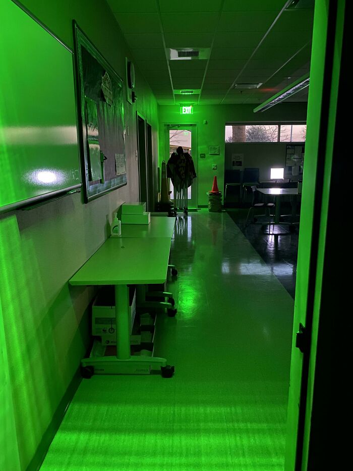 A hallway lit in green light, resembling a scene from a videogame.