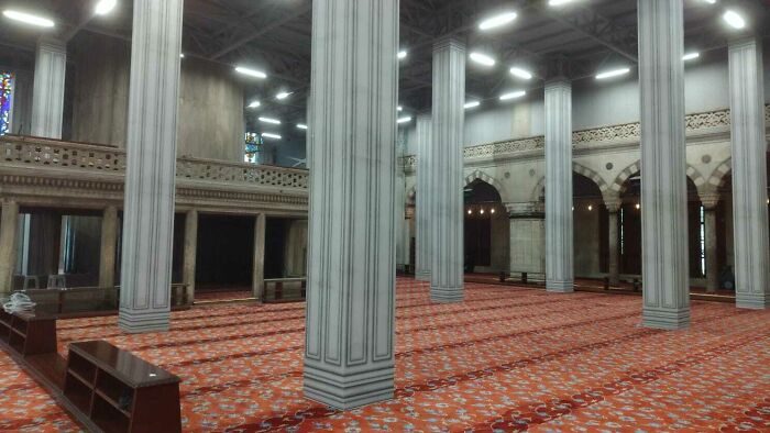 Large room with tall columns and patterned carpet, evoking a look like bad renders in real-life photos.