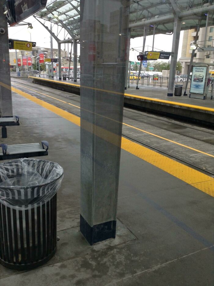 Train station with optical illusion, resembling bad renders, featuring a misaligned trash can and pillar.