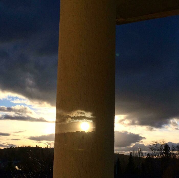 Sunset reflection on a pillar, creating a surreal effect resembling bad renders.