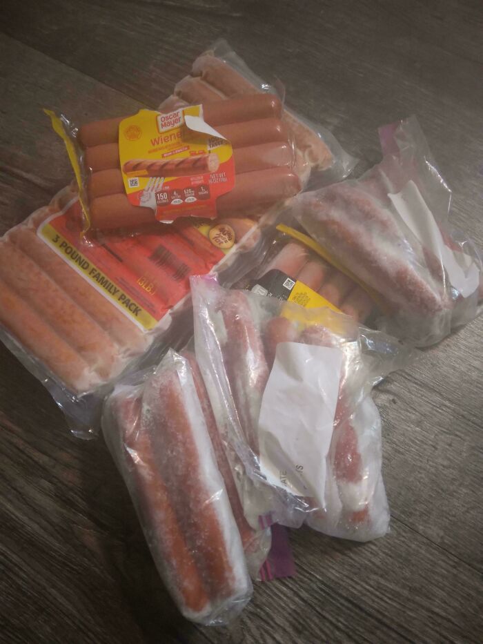 Packages of frozen hot dogs scattered on a wooden floor, highlighting a common issue with horrible roommates.