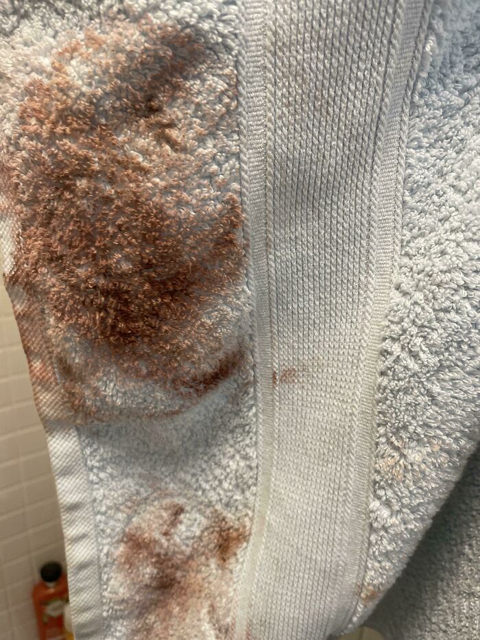 Dirty towel with brown stains, showcasing signs of horrible roommates' neglect in a shared bathroom.