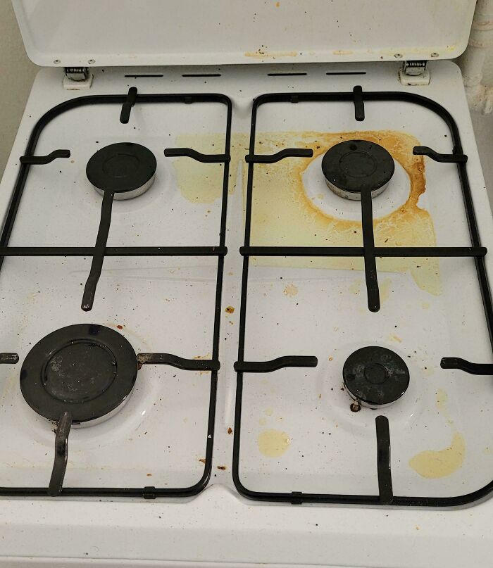 Dirty stove top with food stains, a sign of horrible roommates and poor cleaning habits.