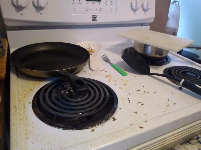 Messy kitchen stove with dirty pans and utensils, highlighting issues with horrible roommates.