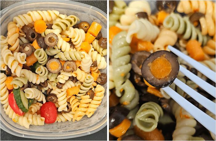 A close-up of rotini pasta salad in a container, highlighting a satisfying perfect fit of sliced olives and carrots on a fork.