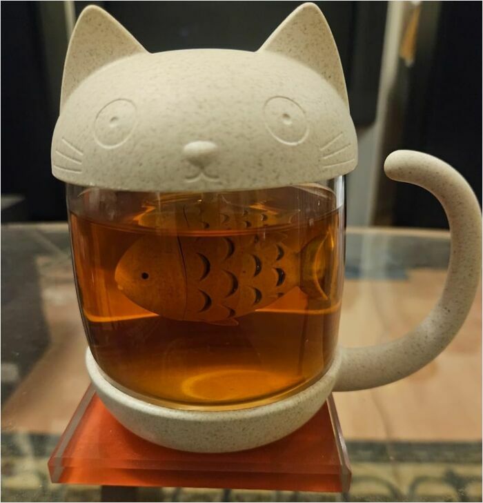 Cat-themed tea infuser mug with fish design, showcasing one of the coolest things we covet.