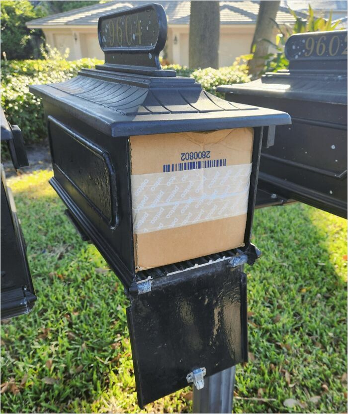 Package fitting perfectly in a black mailbox, showcasing a satisfying perfect fit.