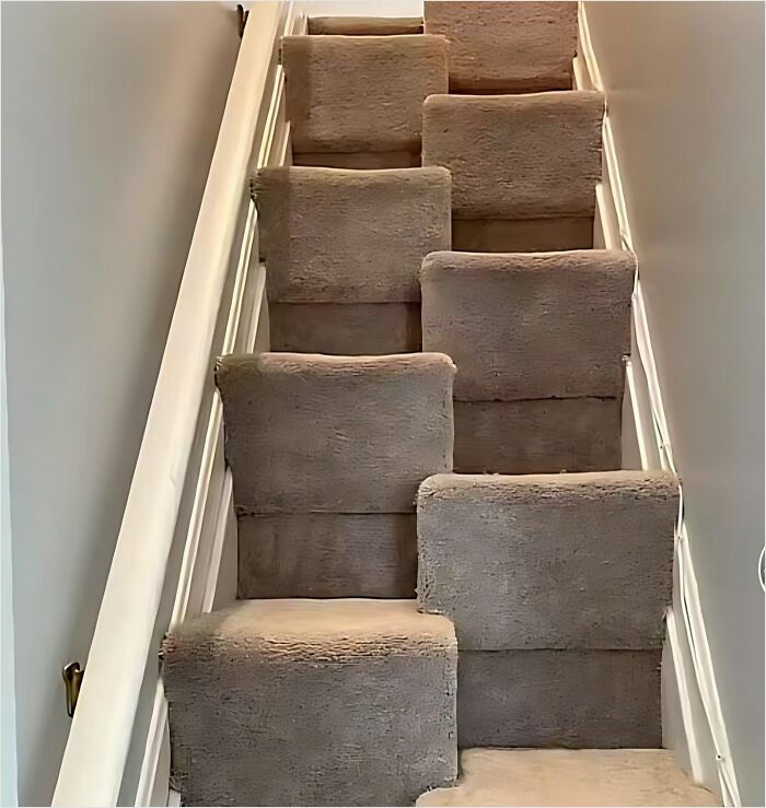 Construction fail with misaligned carpeted stairs, creating an unusual and humorous step pattern.