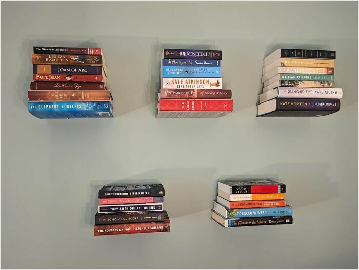 Books creatively organized on wall shelves.