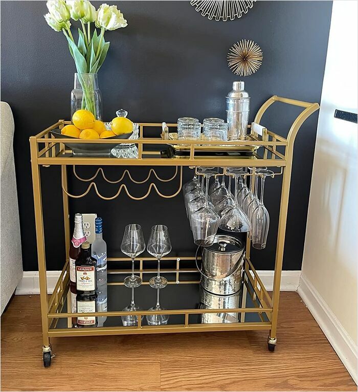 Elegant gold bar cart with glassware and bottles, featuring Amazon furniture with excellent reviews.