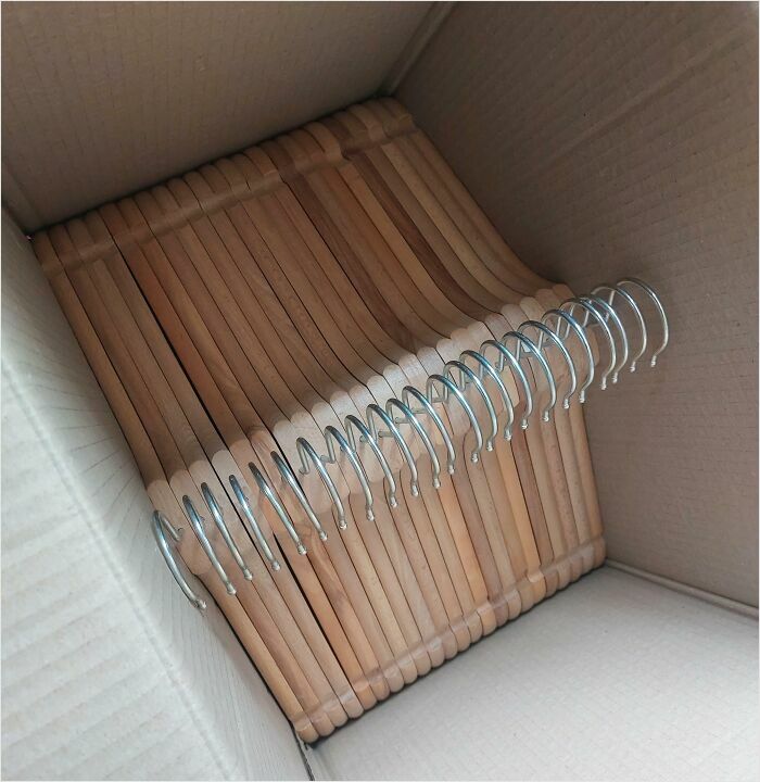 Perfectly fit wooden hangers arranged neatly in a cardboard box.