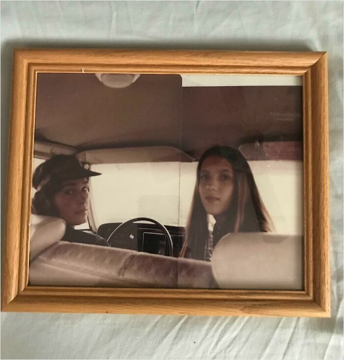 Vintage photo in wood frame, showing two people seated in a car, embodying a satisfying perfect fit.