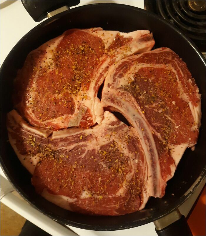 Perfect fit ribeye steaks seasoned and arranged in a pan.