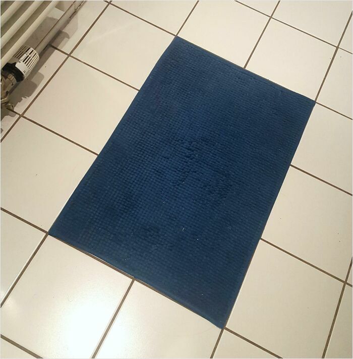 Blue mat perfectly aligned on white tiled floor, showcasing satisfying perfect fit.