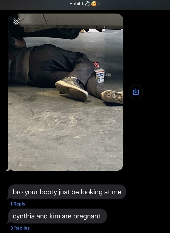 Mechanic working under a car with humorous text messages, related to best texts of 2024.