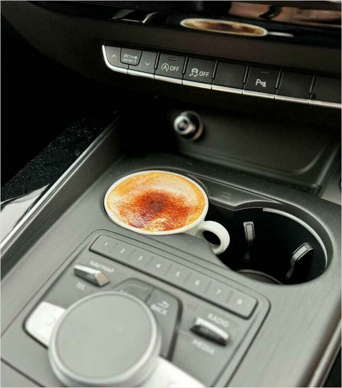 Coffee cup fits perfectly in car's cup holder, showcasing a satisfying-perfect-fit moment.