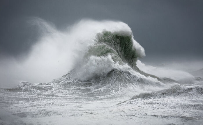 Fascinating wave captured by photographer, showing powerful ocean swell against a stormy sky.