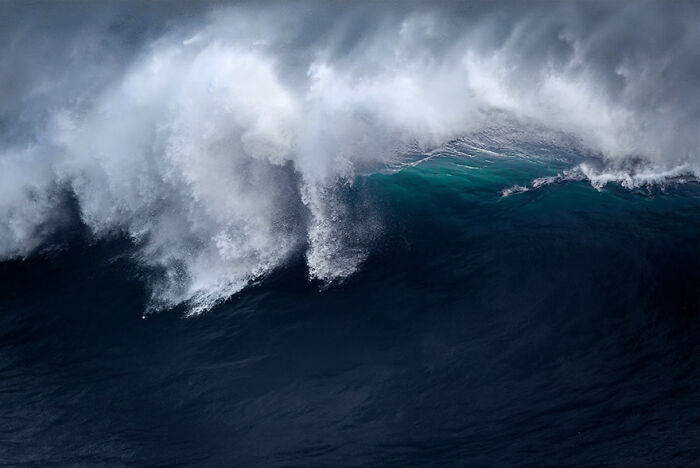 Powerful ocean wave captured in motion, showcasing vibrant blue and white hues.