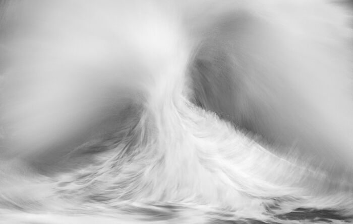 Photographer captures stunning wave in motion, creating a mesmerizing and dynamic scene.