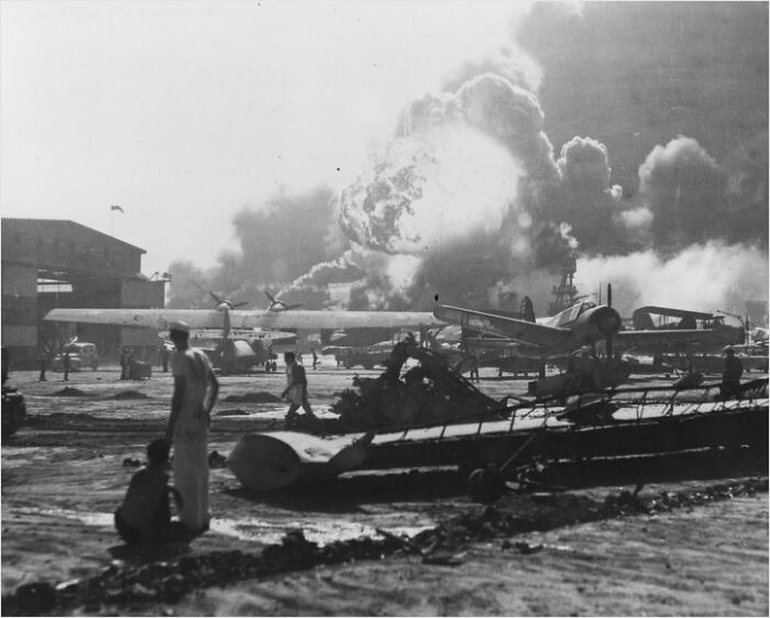 Airfield in chaos with explosions and smoke, highlighting significant historical influence.