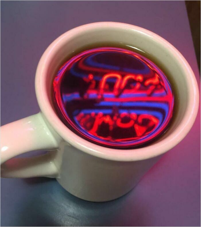 Coffee cup reflecting neon lights, resembling videogames.