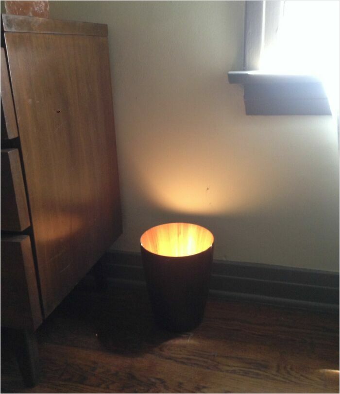 Trash can with light inside, creating a glow that makes it look like a scene from a videogame.