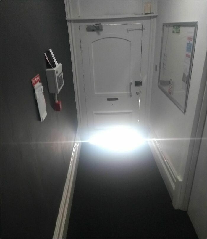 A hallway with a glowing door resembles a videogame scene, creating a surreal effect.