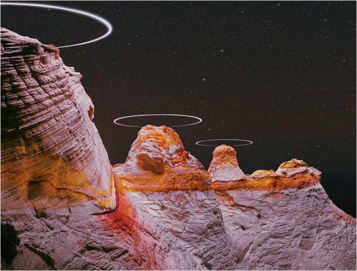 Rock formations at night with glowing rings, resembling a scene from a videogame.