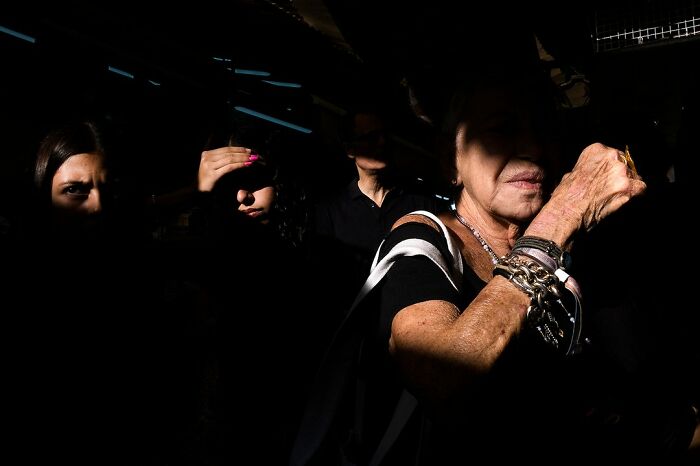 Street view in Israel capturing people, deep shadows, and dramatic lighting, taken by Ilan Ben Yehuda.