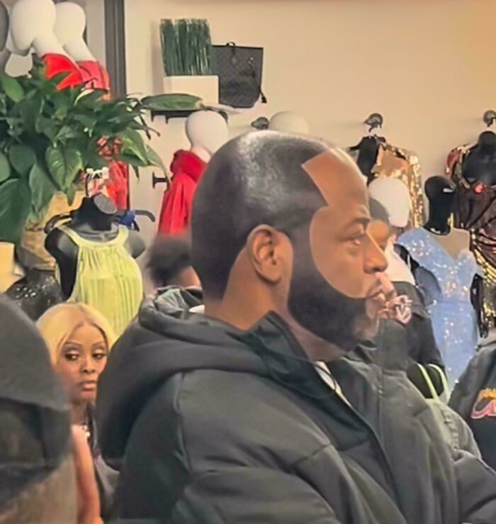 Man with a unique haircut in a clothing store, illustrating a hair accident in a public setting.