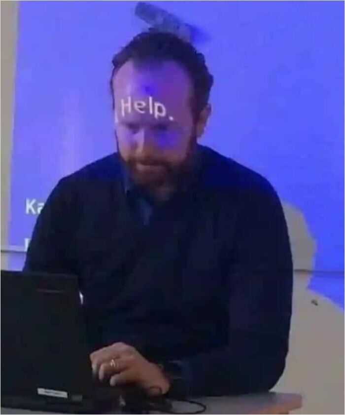 Man at desk with "Help." projected on forehead, creating a weird potential album cover image.