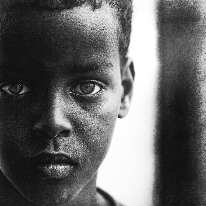 A soulful portrait of a young boy taken by Lee Jeffries, capturing deep emotion and intensity.