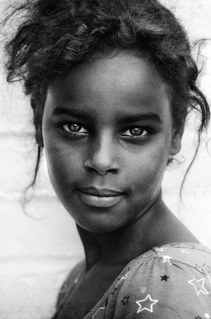 Portrait of a young girl captured by Lee Jeffries, highlighting soulful expression and depth.