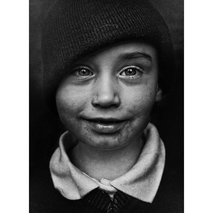 Portrait by Lee Jeffries of a child in a beanie, capturing soulful and expressive eyes.