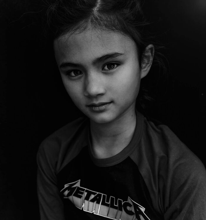 Black and white portrait of a young girl in a Metallica shirt by Lee Jeffries, focusing on soulful expressions.