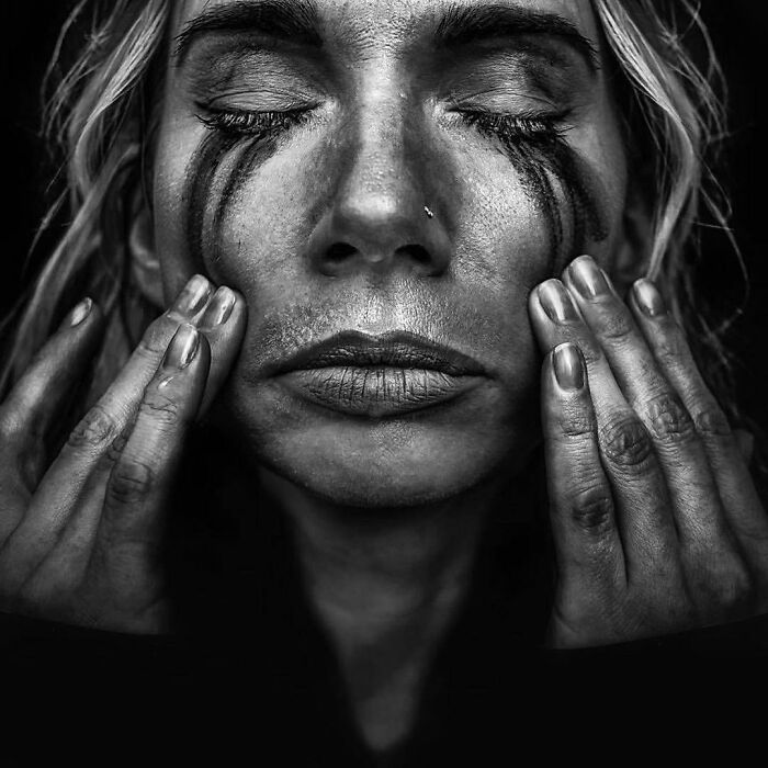 A soulful portrait by Lee Jeffries of a person with eyes closed, displaying emotional depth.