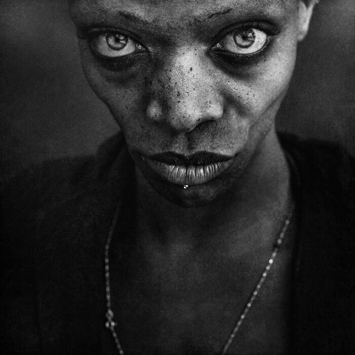 Close-up black and white portrait capturing soulful expression by Lee Jeffries.