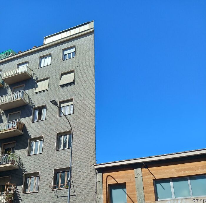 Brick building against a clear sky, resembling bad renders with its flat, geometric features.