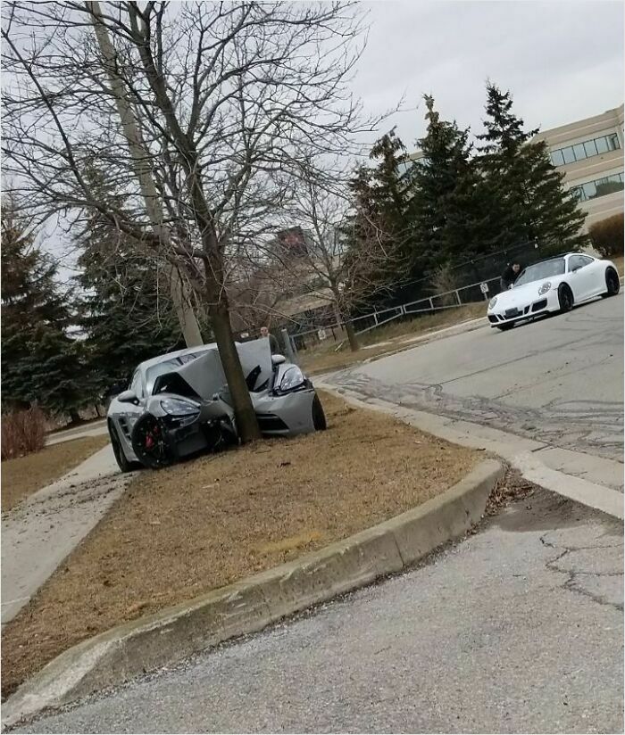 A car crashed into a tree on a suburban street, illustrating risky driving behaviors.