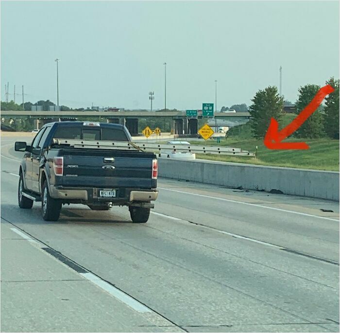 Pickup truck on highway near grass median, with red arrow pointing towards the right.