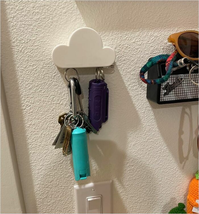 Cloud-shaped key holder on wall, organizing multiple keys and a pair of sunglasses neatly.