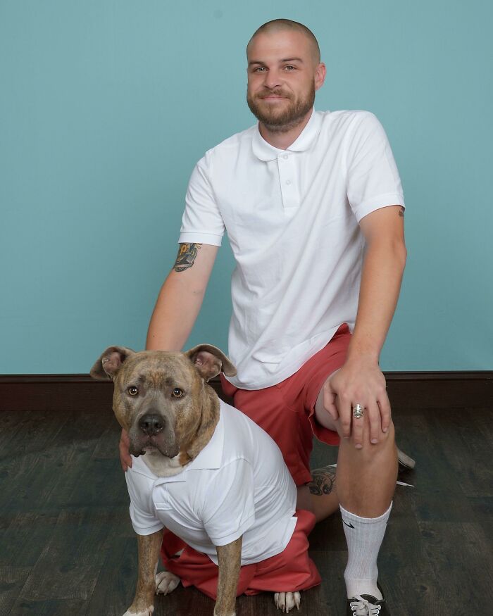 Man posing with his matching dog in polo shirts, showcasing spoiled-pets theme.