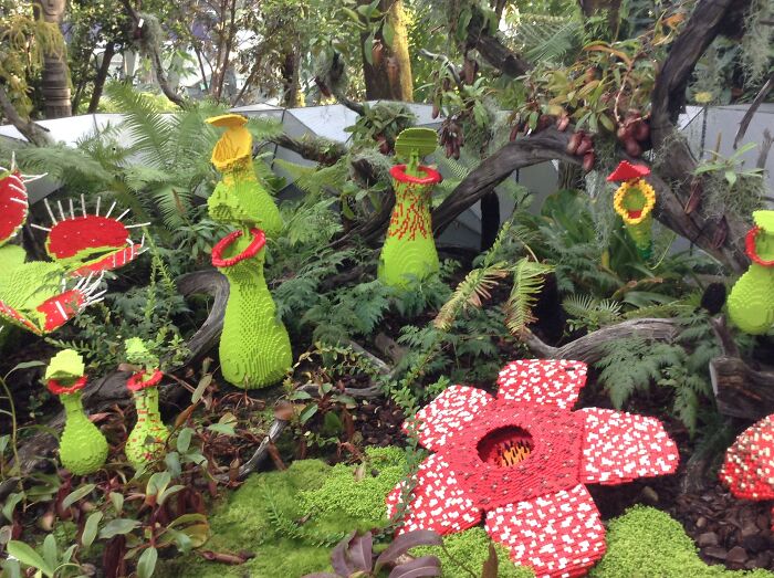 Cool LEGO builds depicting colorful and creative plant sculptures in a garden setting.