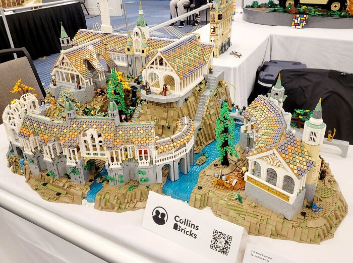 Intricate LEGO build depicting a detailed medieval-style village with colorful roofs and lush greenery.