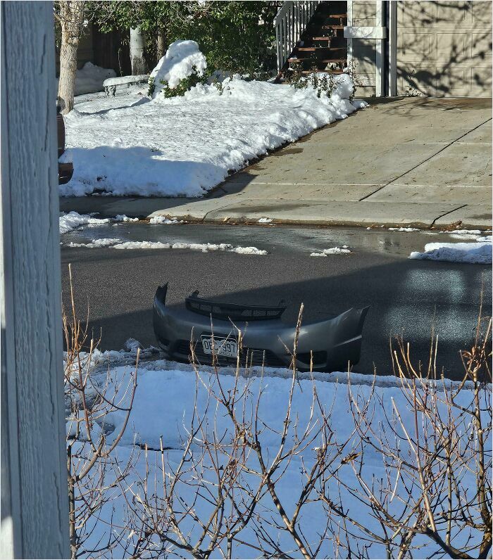 Car bumper seemingly floating oddly in a snowy street, resembling a bad 3D render.