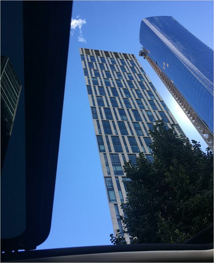 Skyscraper against the blue sky, resembling a bad render with sharp angles and reflections.