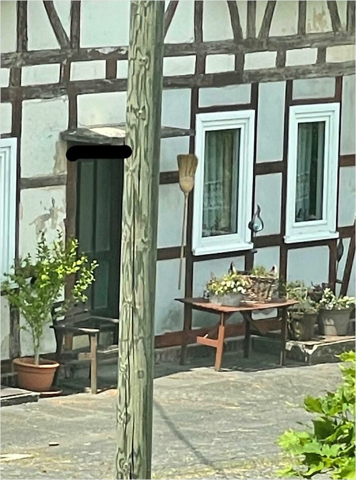 Half-timbered house with plants and a table, looking like bad renders.