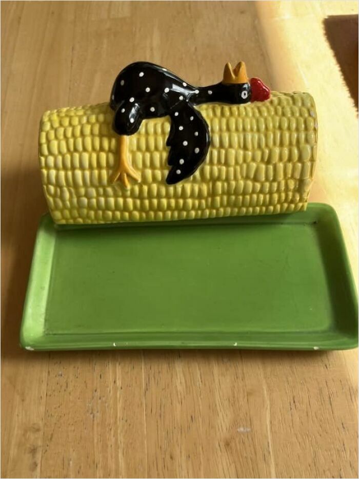 Ceramic corn-shaped butter dish with a quirky black chicken design.