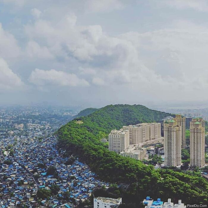 Urban landscape with lush green hills and high-rise buildings, featuring a stunning contrast in the incredible world photos.