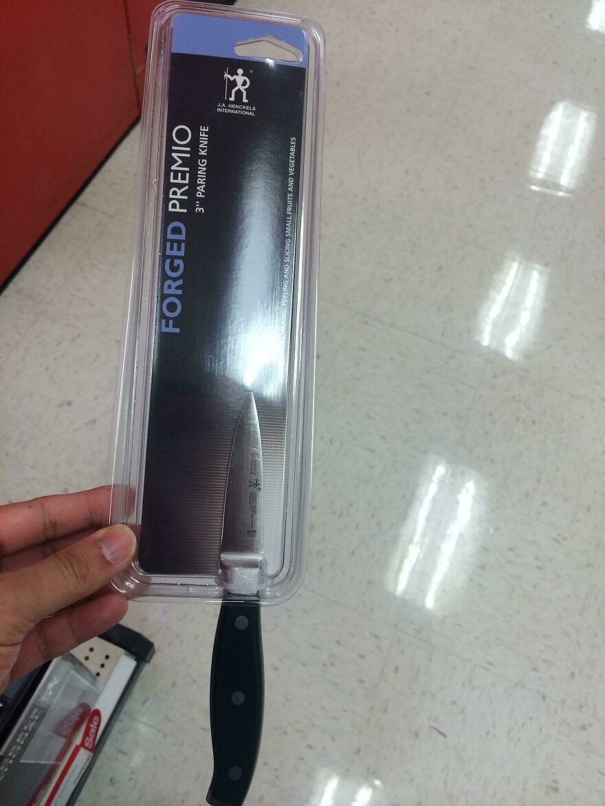 Plastic packaging enclosing a small knife, highlighting wasteful unnecessary packaging practices.